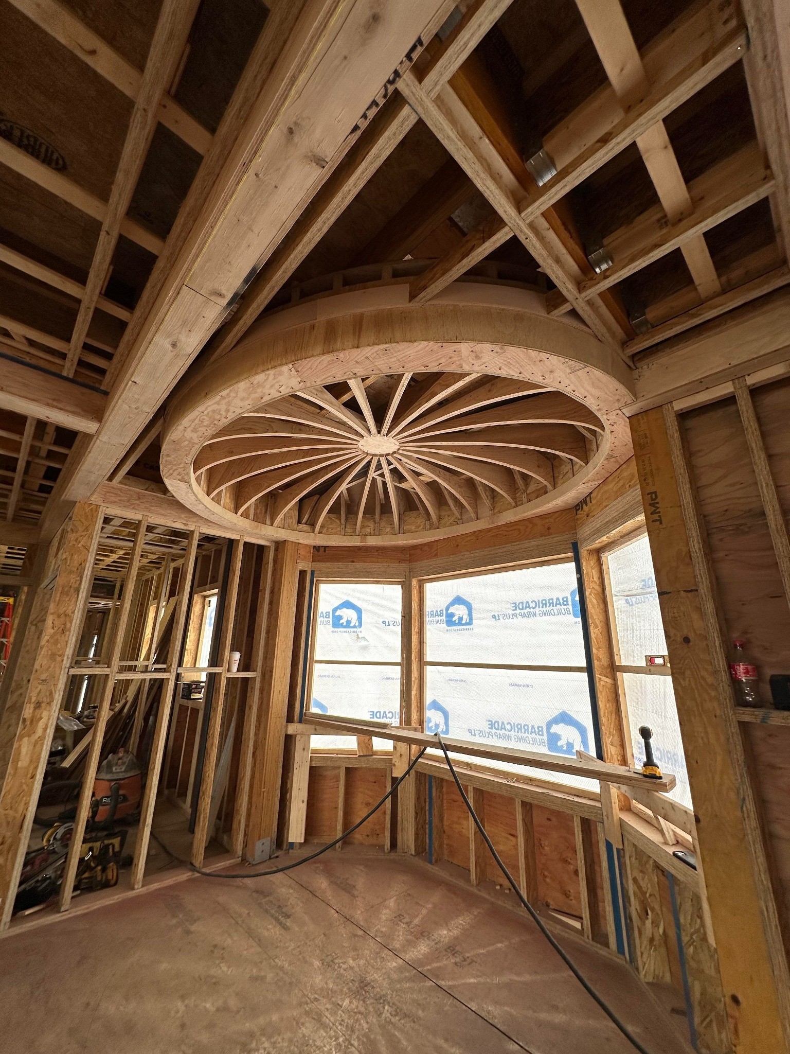 Jobsite photograph of custom curved ceiling framing with a plywood perimeter and radiating wood members