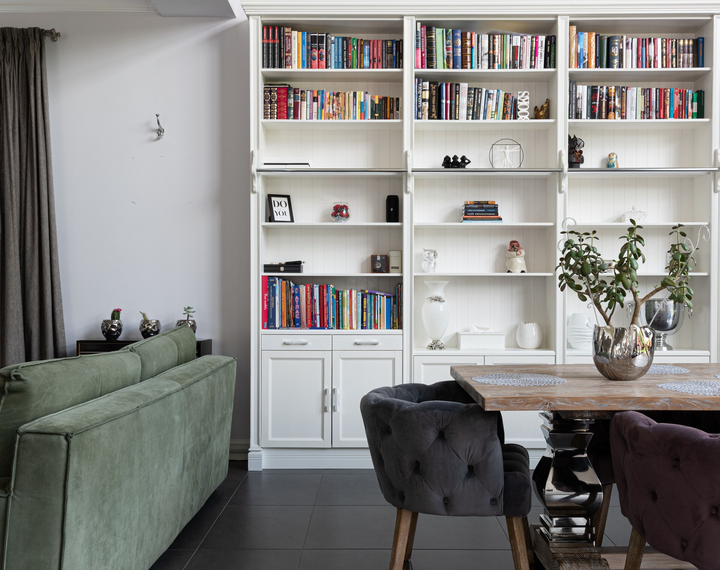High-resolution real photograph of full-wall white built-in bookcases and lower cabinets