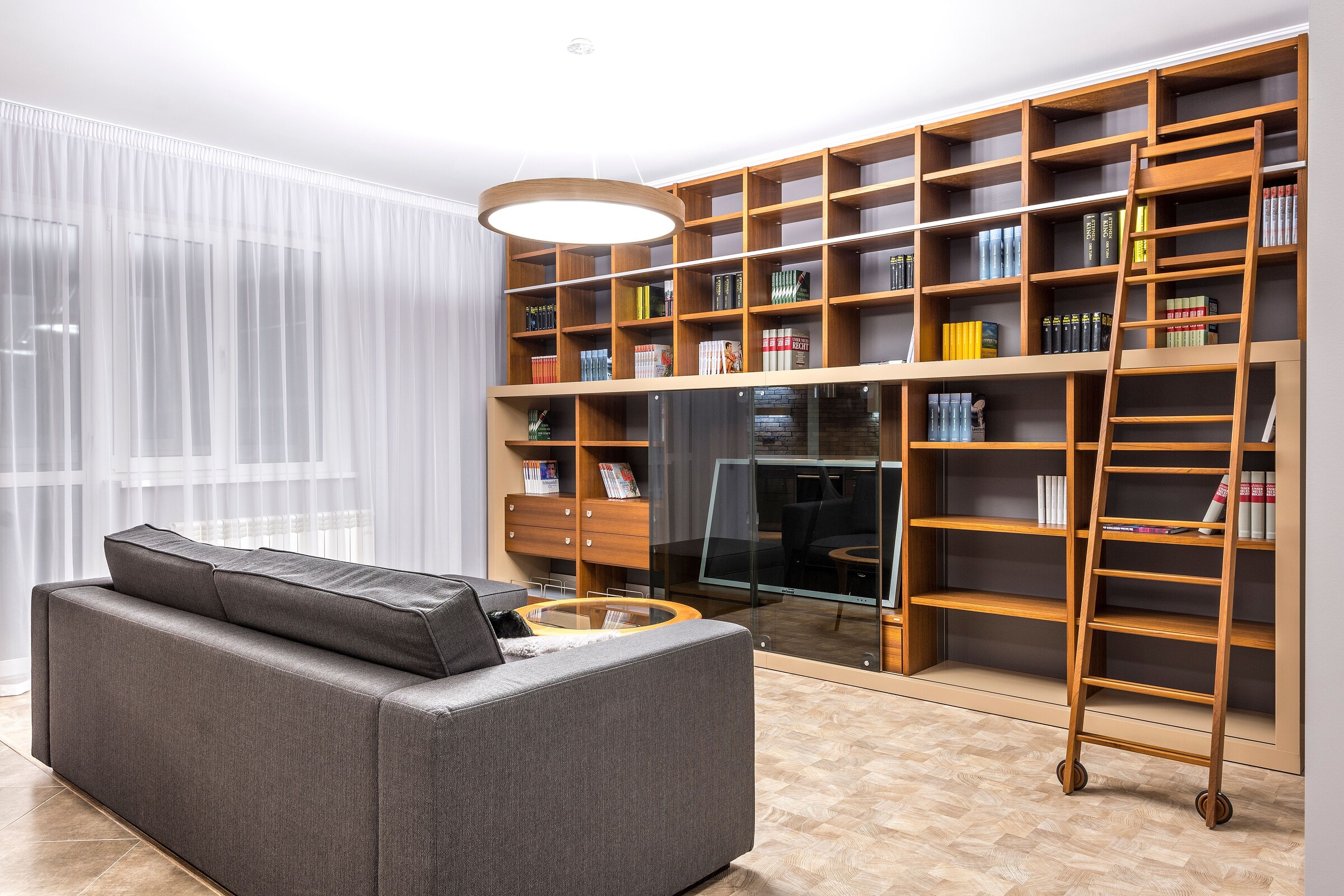High-resolution real photograph of a custom wood library wall with a rolling ladder